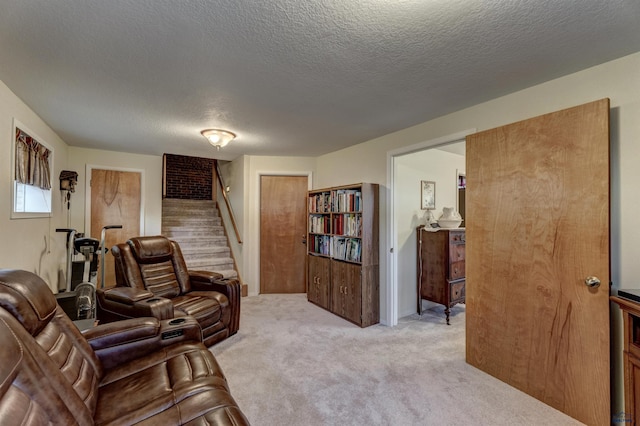 living area with stairs, a textured ceiling, and light colored carpet