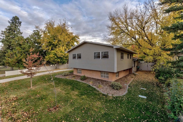 view of side of home with fence and a yard