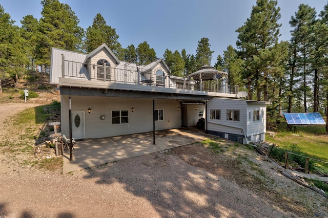 view of front of house featuring a patio, a gazebo, and solar panels