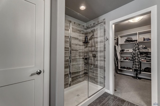 full bath with recessed lighting, a spacious closet, and a shower stall