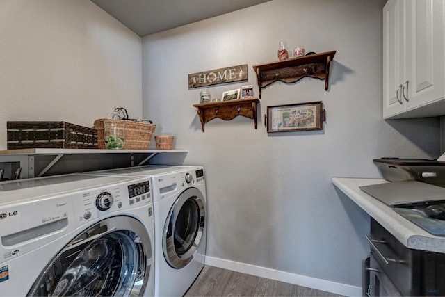 laundry area featuring light wood-type flooring, baseboards, cabinet space, and washing machine and clothes dryer