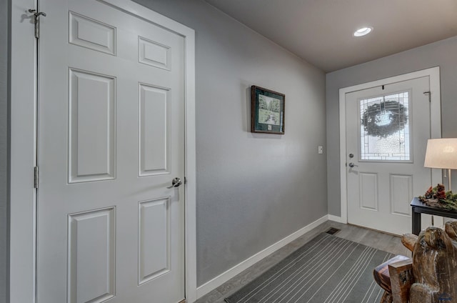 doorway to outside with wood finished floors and baseboards