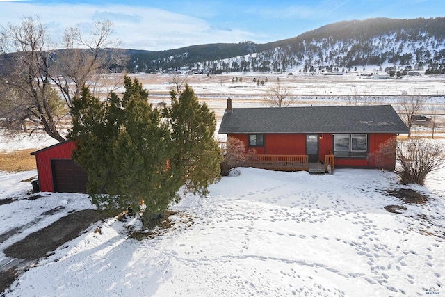 exterior space with an outbuilding, a mountain view, and a detached garage