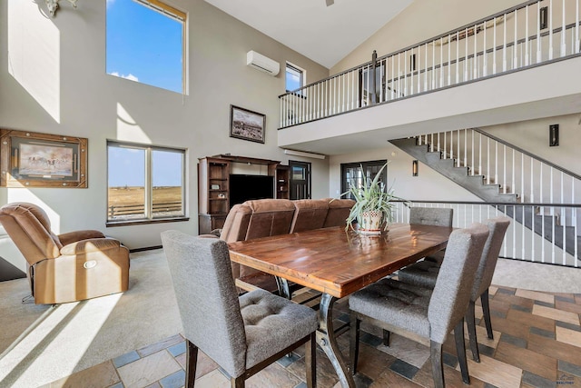 dining area with stairs, plenty of natural light, high vaulted ceiling, and a wall mounted AC