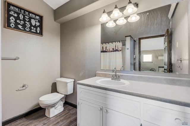 full bath with a textured wall, toilet, a shower with shower curtain, wood finished floors, and vanity