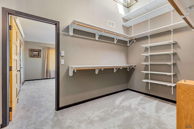 walk in closet featuring visible vents and light colored carpet