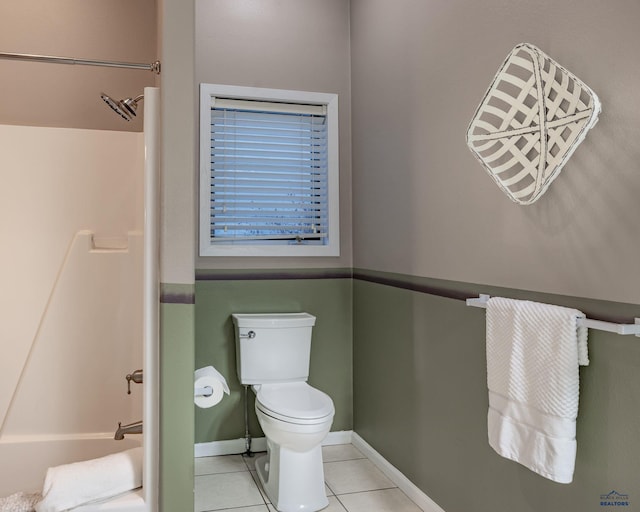 bathroom with toilet, tile patterned flooring, baseboards, and shower / washtub combination