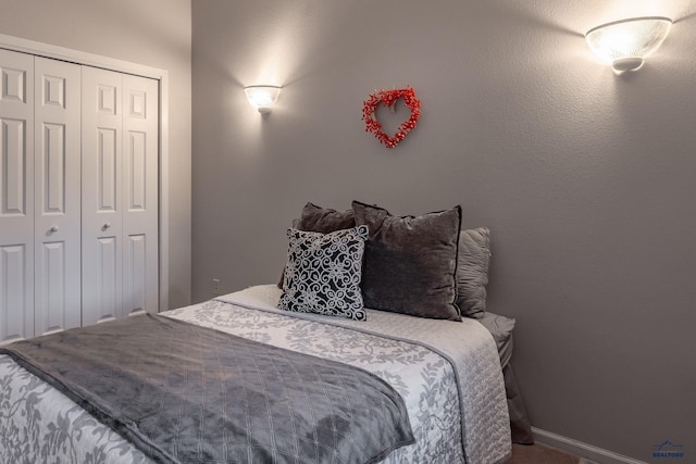 bedroom featuring baseboards and a closet