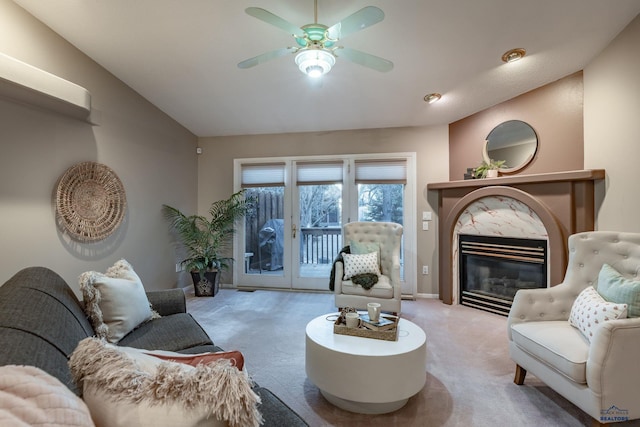 living area featuring lofted ceiling, light carpet, a high end fireplace, baseboards, and a ceiling fan