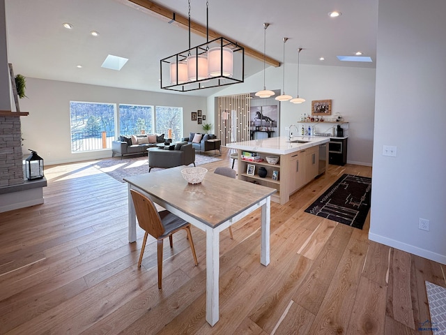 20216 Ponderosa Dr, Whitewood, SD 57793 - dining room featuring a skylight, baseboards, light wood-style flooring, recessed lighting, and high vaulted ceiling