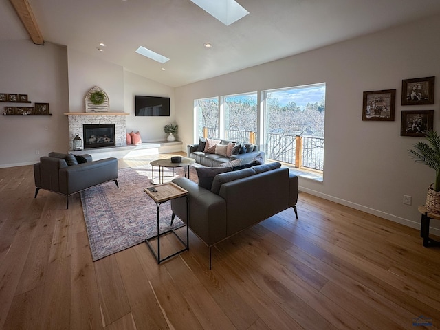 20216 Ponderosa Dr, Whitewood, SD 57793 - living room featuring a skylight, light wood finished floors, baseboards, a glass covered fireplace, and recessed lighting