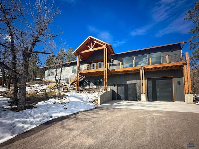 view of front of property featuring a garage, driveway, and stairs