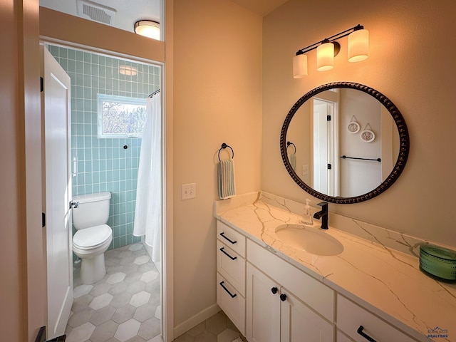 20216 Ponderosa Dr, Whitewood, SD 57793 - full bathroom with tile patterned floors, toilet, vanity, a shower with shower curtain, and tile walls