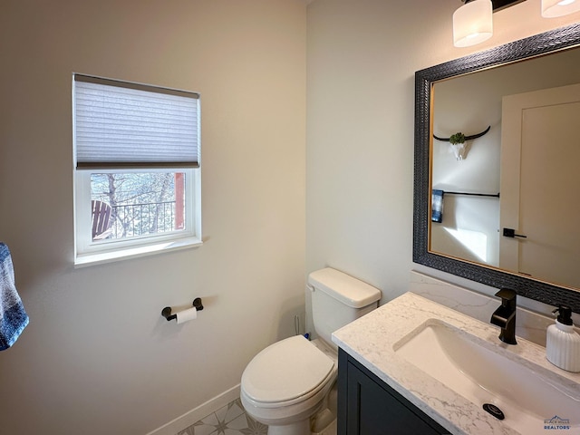 20216 Ponderosa Dr, Whitewood, SD 57793 - bathroom featuring toilet, baseboards, and vanity