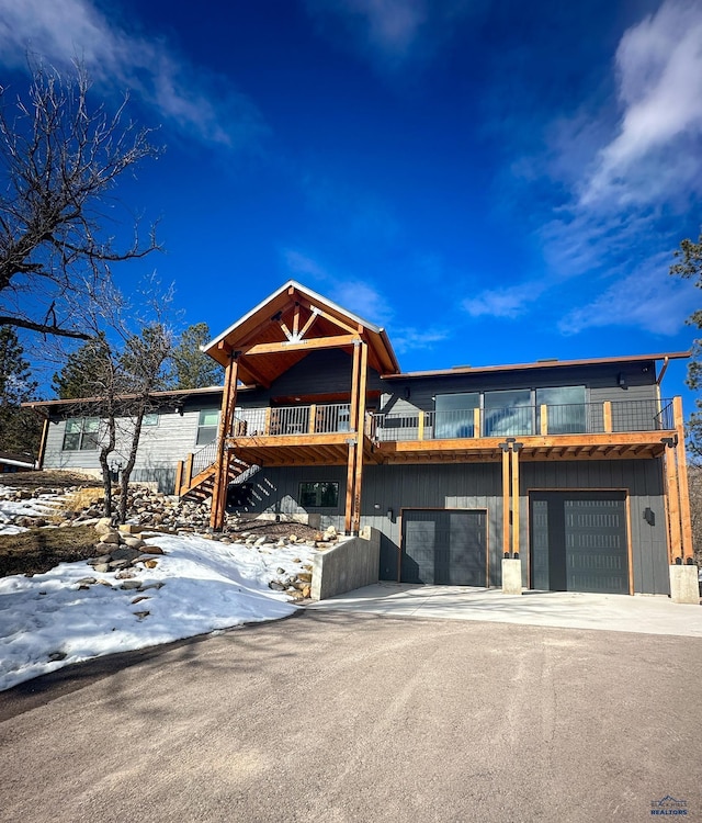 20216 Ponderosa Dr, Whitewood, SD 57793 - view of front facade with a garage, board and batten siding, asphalt driveway, and stairs