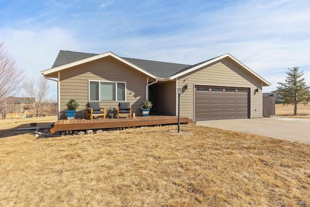 single story home featuring a garage, concrete driveway, roof with shingles, a wooden deck, and a front yard