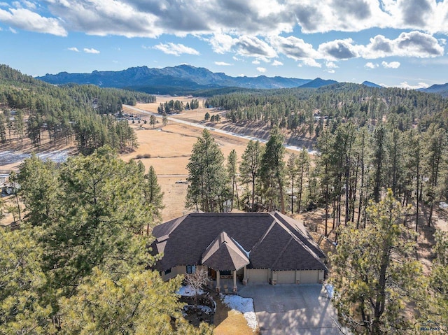 birds eye view of property featuring a mountain view and a view of trees