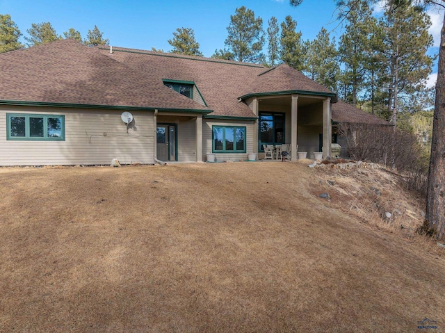 view of front of house with a shingled roof and a front yard