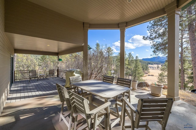 view of patio with a deck with mountain view and outdoor dining space