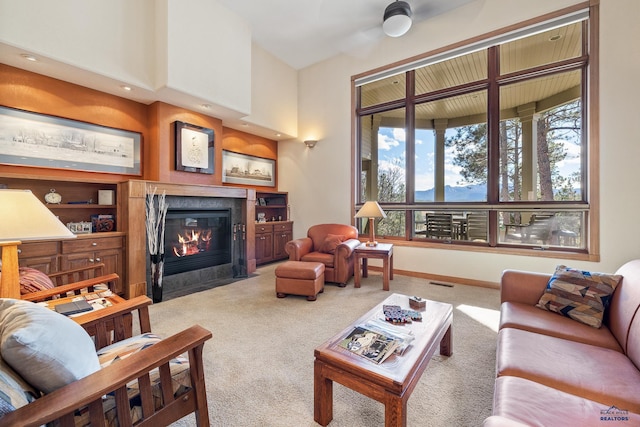 living room featuring baseboards, carpet, visible vents, and a tiled fireplace