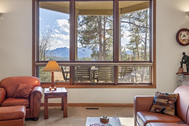 carpeted living area with visible vents and baseboards