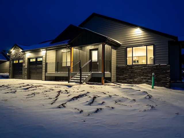 view of front of property featuring stone siding, board and batten siding, and an attached garage