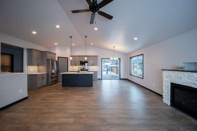 kitchen featuring a sink, open floor plan, light countertops, appliances with stainless steel finishes, and gray cabinets