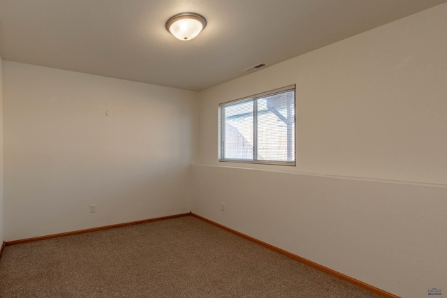 empty room with carpet flooring, visible vents, and baseboards