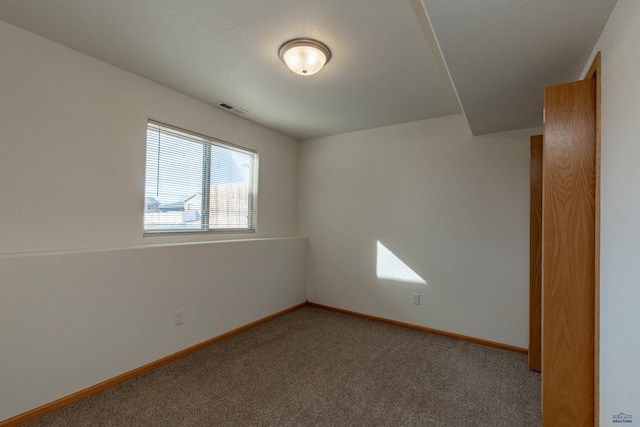 empty room featuring light carpet, visible vents, and baseboards