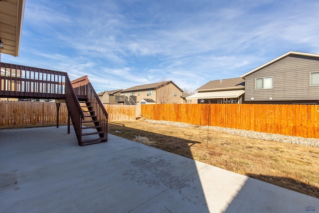 view of yard with stairs, a patio area, a fenced backyard, and a residential view