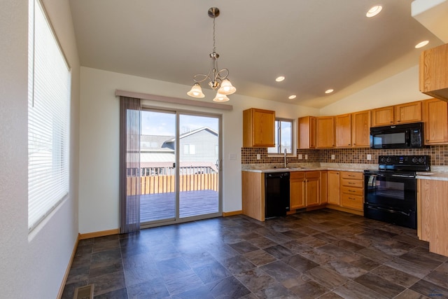 kitchen featuring pendant lighting, tasteful backsplash, light countertops, a sink, and black appliances