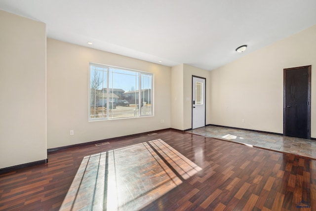 spare room featuring recessed lighting, wood finished floors, visible vents, baseboards, and vaulted ceiling