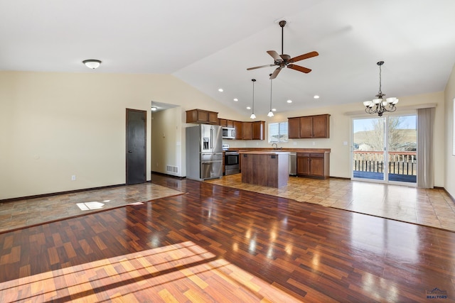 unfurnished living room featuring visible vents, vaulted ceiling, a sink, wood finished floors, and ceiling fan with notable chandelier