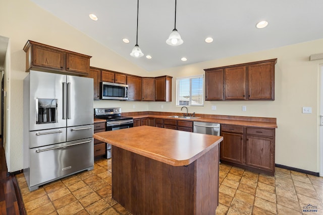 kitchen with lofted ceiling, stainless steel appliances, a sink, a center island, and pendant lighting