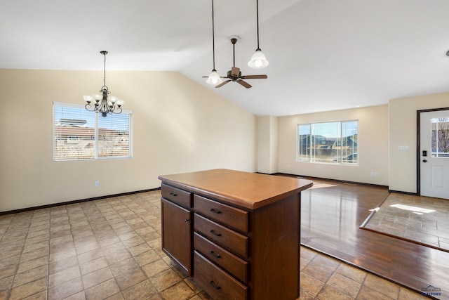 kitchen featuring pendant lighting, lofted ceiling, a center island, and baseboards