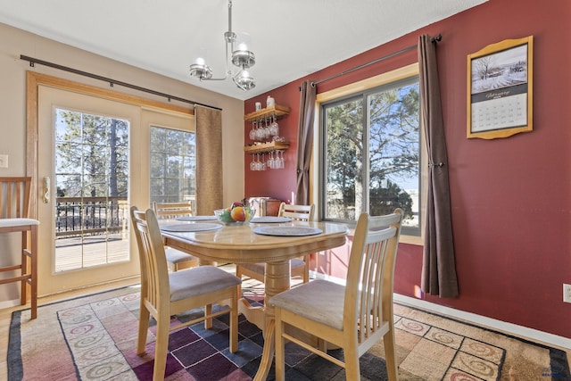 dining area with a chandelier and baseboards