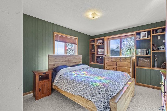 carpeted bedroom featuring multiple windows and baseboards