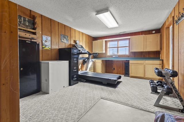 workout area with carpet floors, beverage cooler, wooden walls, and a textured ceiling