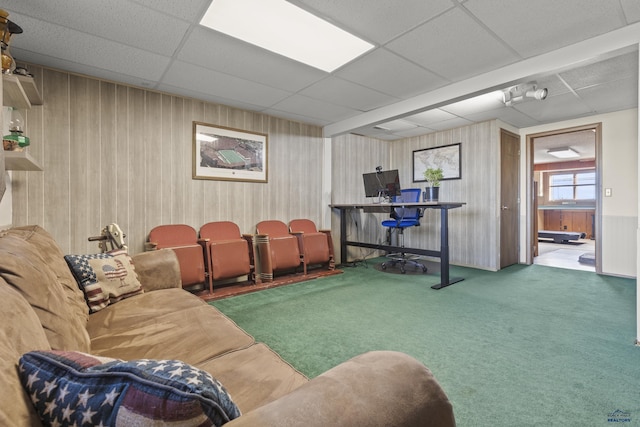 carpeted living area with a drop ceiling