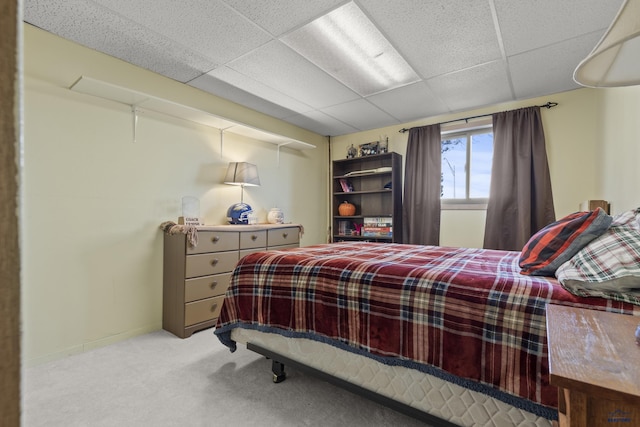 bedroom with baseboards, carpet flooring, and a drop ceiling