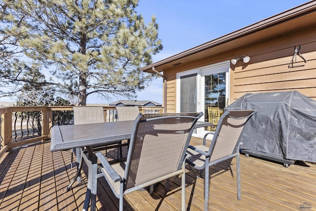 deck with a grill and outdoor dining space