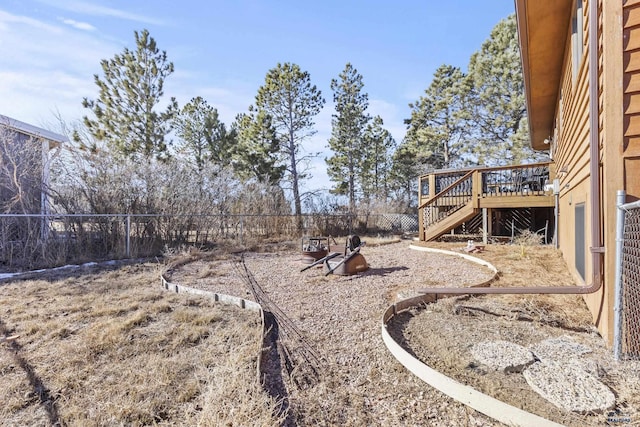 view of yard featuring fence, a deck, and stairs