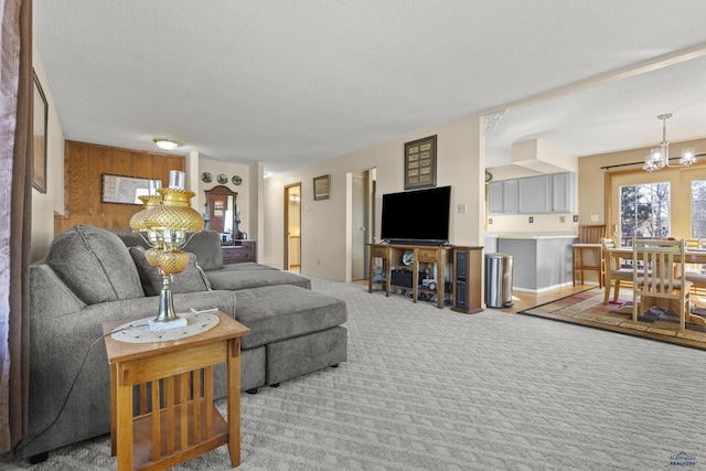 carpeted living room with a textured ceiling and a notable chandelier