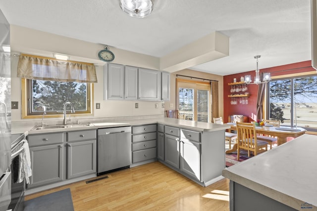 kitchen featuring visible vents, stainless steel appliances, a sink, and gray cabinetry