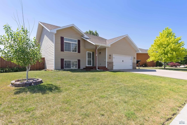 tri-level home featuring a shingled roof, concrete driveway, an attached garage, fence, and a front yard