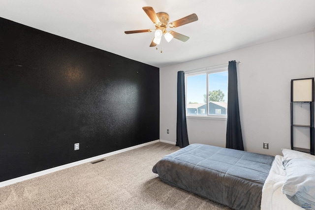 carpeted bedroom featuring ceiling fan, visible vents, and baseboards