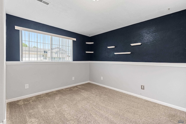 carpeted empty room with visible vents and baseboards