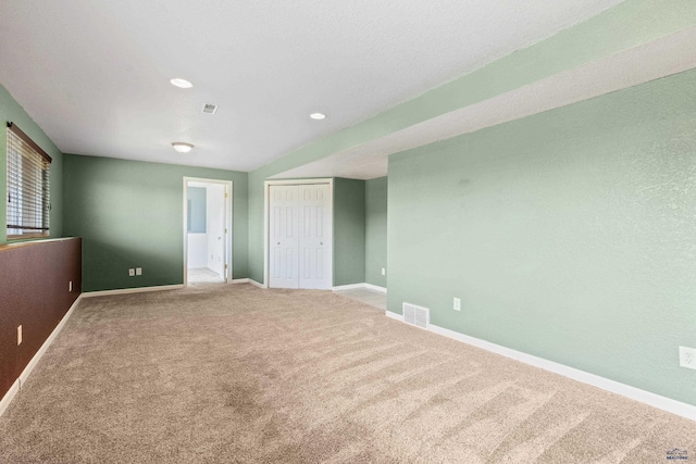 unfurnished room featuring carpet, visible vents, and baseboards