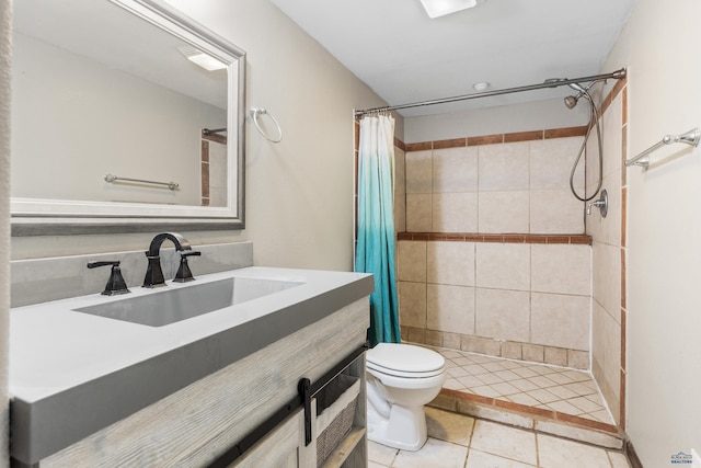 full bathroom with toilet, tile patterned flooring, tiled shower, and vanity