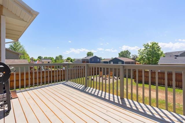 wooden deck featuring a residential view, fence, and a lawn